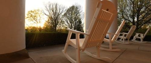 日出时老bwin体育门廊上的白色摇椅